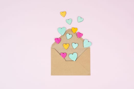 Valentine day greeting card, envelope with hearts on pastel background, love symbol, flat lay