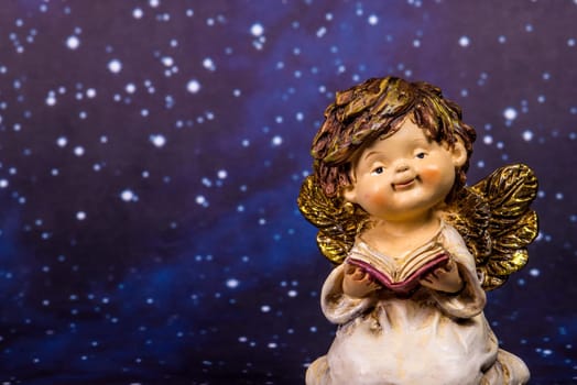 angel with a book on a night sky with stars