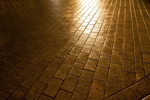 A wet cobblestone pavement in Berlin, Germany.