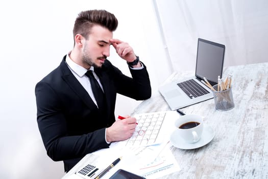 Businessman checking appointments in the calendar at the office.