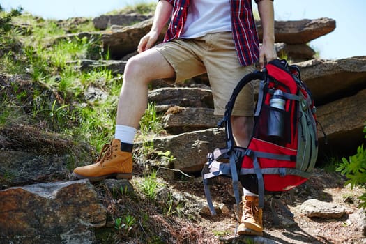 Young traveler with backpack standing on rock