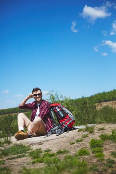 Restful traveler sitting on country road