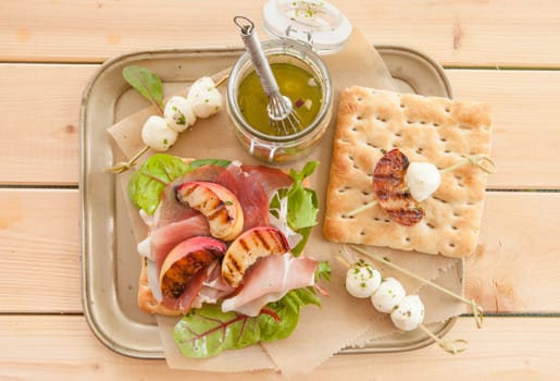 Sandwich with raw ham,grilled peaches and mozzarella