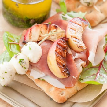 Sandwich with raw ham,grilled peaches and mozzarella