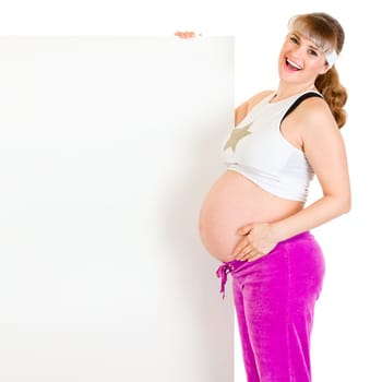 Smiling beautiful pregnant woman holding blank billboard  isolated on white.