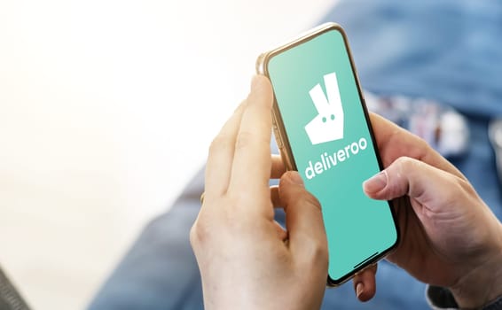 Rome, IT, Nov 2022: Female hands hold a smart-phone with the Deliveroo app on the screen. Deliveroo is a British online food delivery company. Illustrative editorial