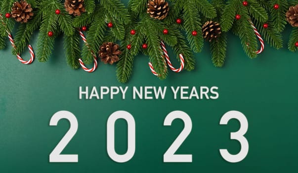 Happy New Year 2023 Background. Top view Christmas wallpaper on green spruce branches with 2023 years number on green background, Flat lay, copy space