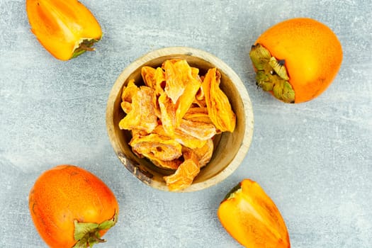 Dried persimmon fruits with fresh persimmon on the table.