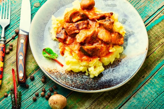 Pieces of stew garnished with mashed potatoes. Yummy meat stew