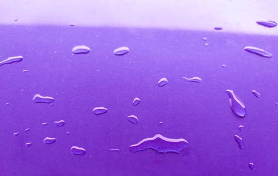 Landscape of drops on the car body after washing it with a pressure gun. Purple color