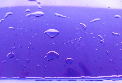 Landscape of drops on the car body after washing it with a pressure gun. Purple color