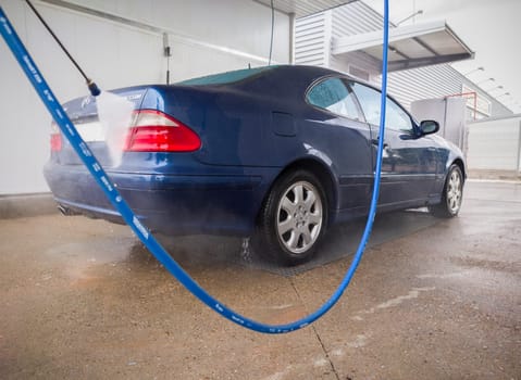 Washing with pressure a Mercedes-Benz CLK 320. Water jet pointing to trunk