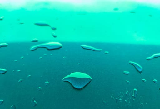 Landscape of drops on the car body after washing it with a pressure gun. Turquoise color