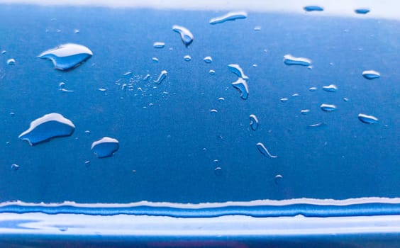 Landscape of drops on the car body after washing it with a pressure gun. Light blue
