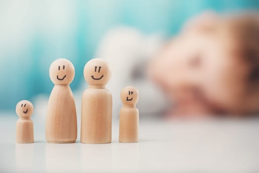 Wooden figures of the family standing on the table. Concept of the love, togetherness and relation between peoples.