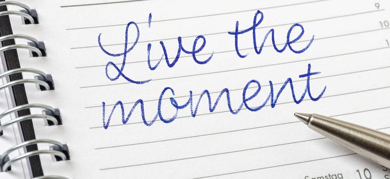 Live the moment written on a calendar page