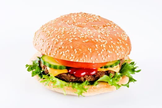 Beefburger in sesame seed bun with vegetables isolated