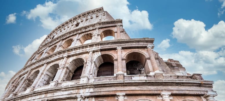 Detail of Colosseum in Rome (Roma), Italy. Also named Coliseum, this is the most famous Italian sightseeing. Spectacular blue sky in background.