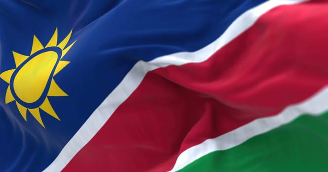 Close-up view of the Namibia national flag waving. Republic of Namibia is a country in Southern Africa. Fabric textured background. Selective focus. 3D illustration