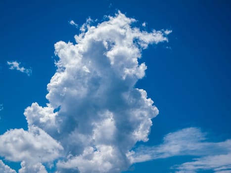 View of a towering cloud in front of a blue summer sky in Bavaria..