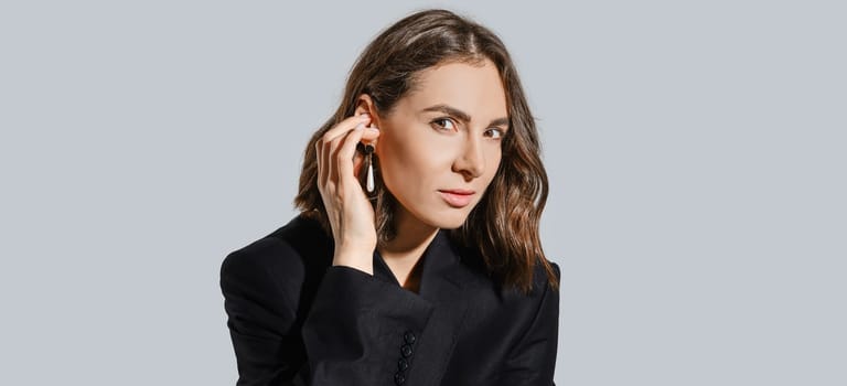 Portrait of tricky woman touching her ear with earring