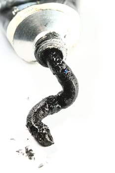 black paint in tube on white paper