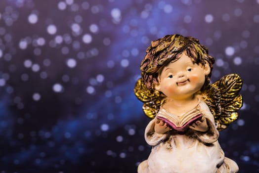 angel with a book on a night sky with stars