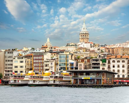City view of Istanbul skyline, from the Bosporous strait overlooking Galata Tower, Karakoy ferry terminal, and docked ferry boats, Istanbul, Turkey