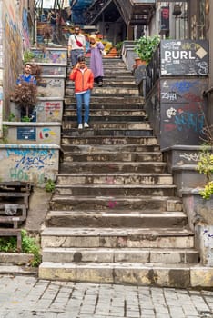 Istanbul, Turkey - August 25, 2022: Walkway with colorful stairs between stone walls leading to Galata Tower, located on Banks Street in Galata, Karakoy district of Istanbul