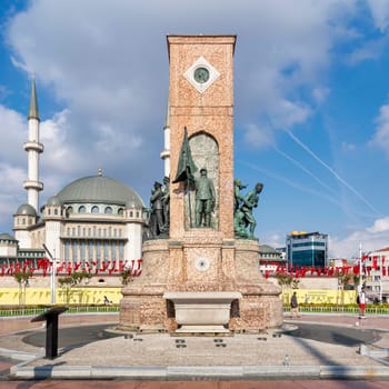 Istanbul, Turkey - September 2, 2022: Republic Monument, or Cumhuriyet Aniti Statue, with Taksim Mosque in the background, at Taksim Square, in a sunny summer day
