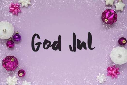 Christmas Card With Swedish Text God Jul Means Merry Christmas. Purple Christmas Background With Romantic And Brilliant Decoration Like Balls And Snowflakes
