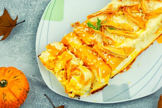 Homemade cakes, autumn recipe. Cottage cheese pumpkin casserole decorated with orange peels.
