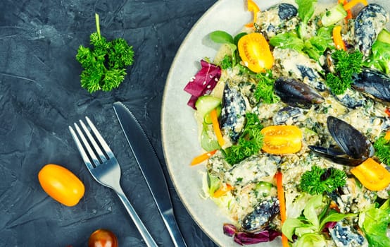 Delicious salad with tomato, pepper, green and mussels. Keto diet