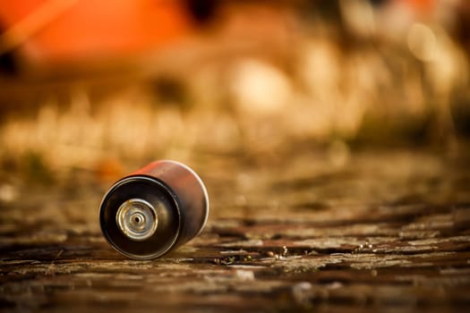 A used and empty spay can for graffiti lies on a floor of stones, clinkers.