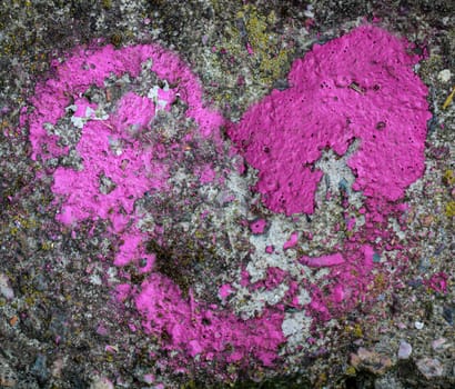 The remains of a pink colored heart on a stone.