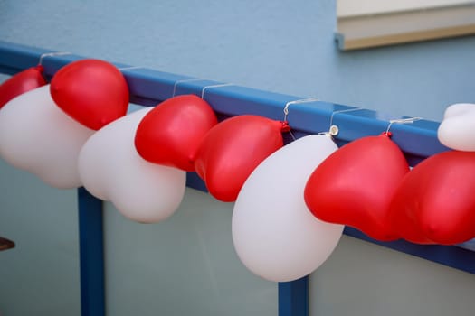Balloons in the shape of a heart attached to a railing for decoration at a wedding.