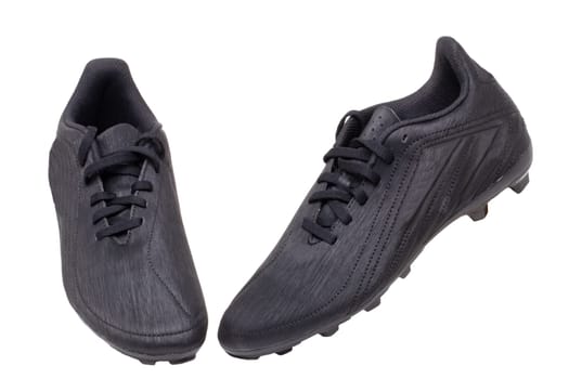 Closeup of a pair of black leather football boots isolated on white background. Professional athletics boys outdoor training shoes. Sports shoes.
