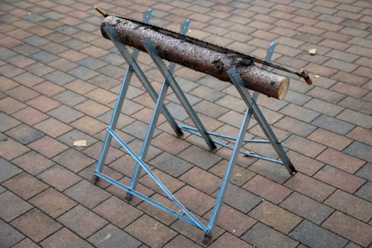 Details of a sawhorse with log and saw at a wedding.