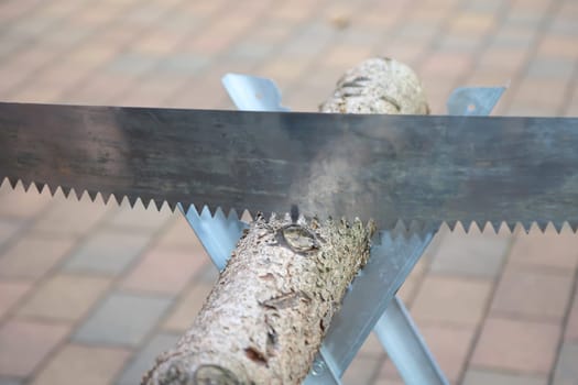 Details of a sawhorse with log and saw at a wedding.