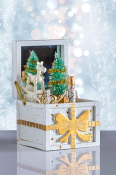 Christmas card. Old wooden music box with a christmas song on a table over abstract bright background. The Christmas tree and the figures are moving. Clipping path. Christmas tree music box.