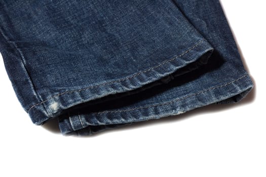 Slightly frayed blue jeans hem on white background