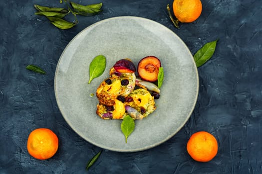 Prepared pork chop cooked with plums and tangerine. Baked meat steak meat in sweet fruits sauce