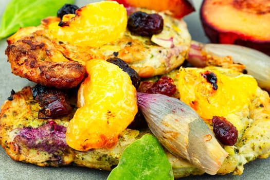 Prepared pork chop cooked with plums and tangerine. Baked meat steak meat in sweet fruits sauce