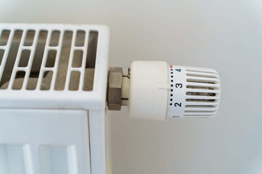 Close-up of the heating radiator adjustment knob, mounted in the middle position. The concept of saving heat energy in connection with the energy crisis.