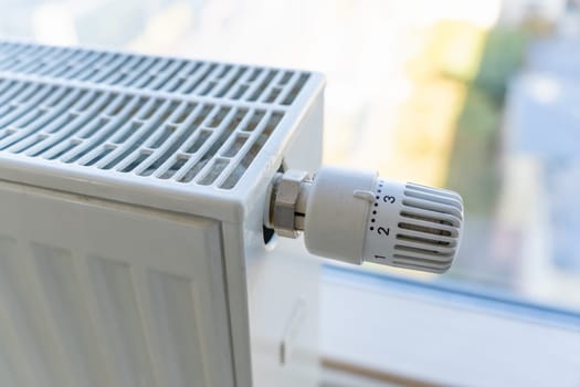 Heating radiator with adjustment knob installed on the middle position in a residential apartment.