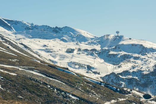 View of the ski resort in the high snowy mountains in winter with clear weather and bright snow.