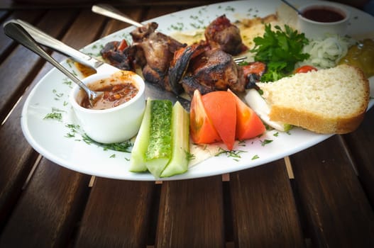 Nice and tasty dish of roasted meat with vegetables and souces