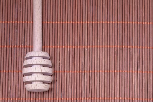 Wood Honey spoon on a nice wicker carpet as background
