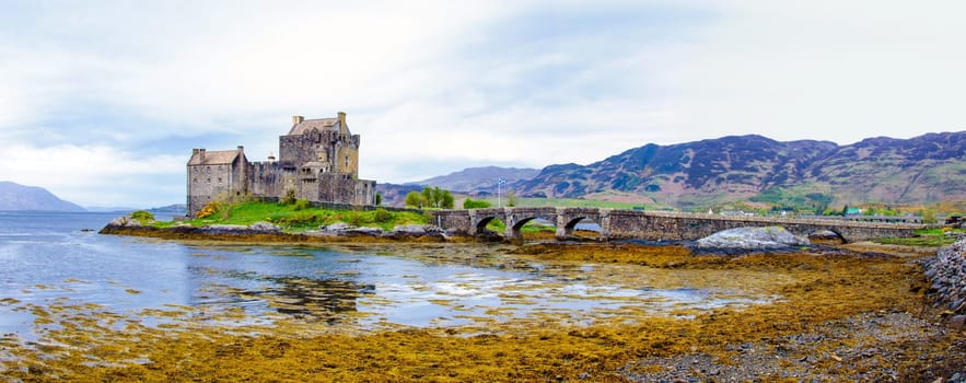 Panoramic view of famous Eilean Donan Castle in Scotland, UK. Situated on a small isle at the meeting point of three sea lochs - Loch Long, Loch Duich and Loch Alsh, is one of the most iconic images of Scotland.