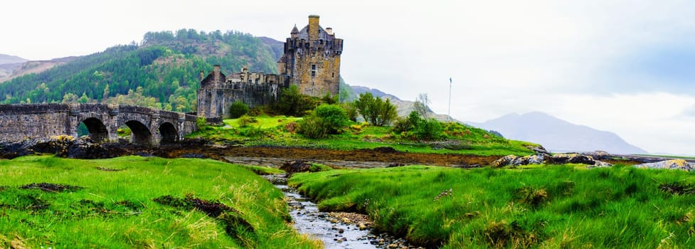 Panoramic view of famous Eilean Donan Castle in Scotland, UK. Situated on a small isle at the meeting point of three sea lochs - Loch Long, Loch Duich and Loch Alsh, is one of the most iconic images of Scotland.